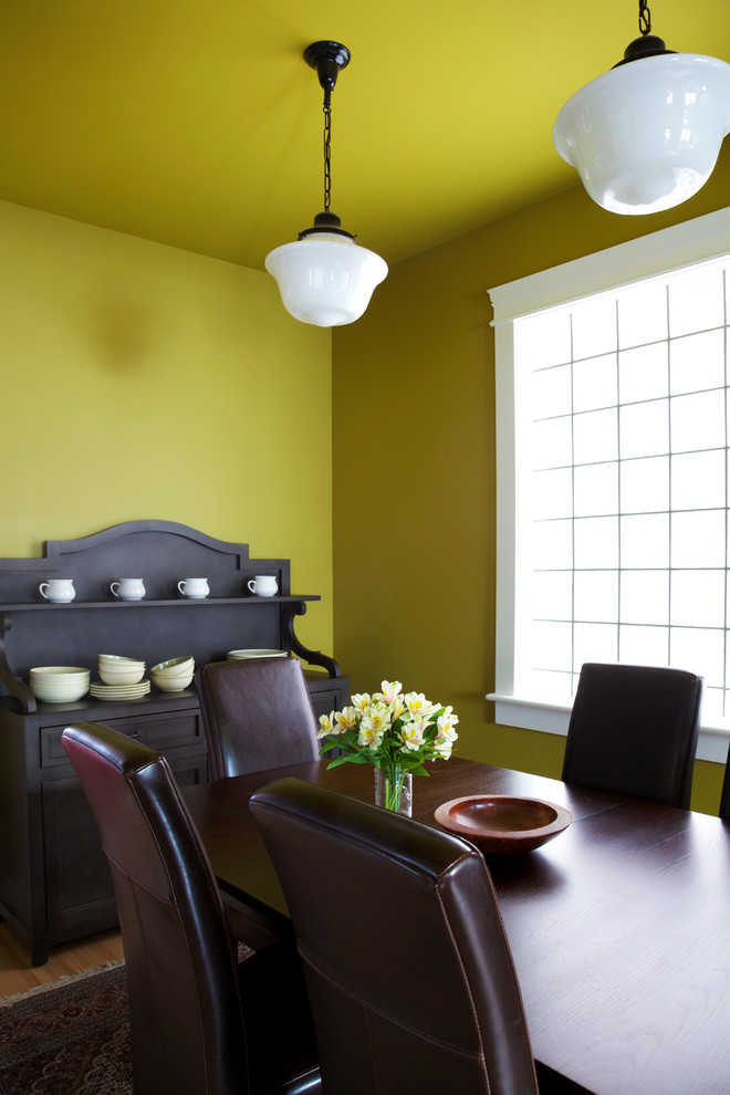 Idéer för mellanstora vintage separata matplatser, med gula väggar, mellanmörkt trägolv och brunt golv