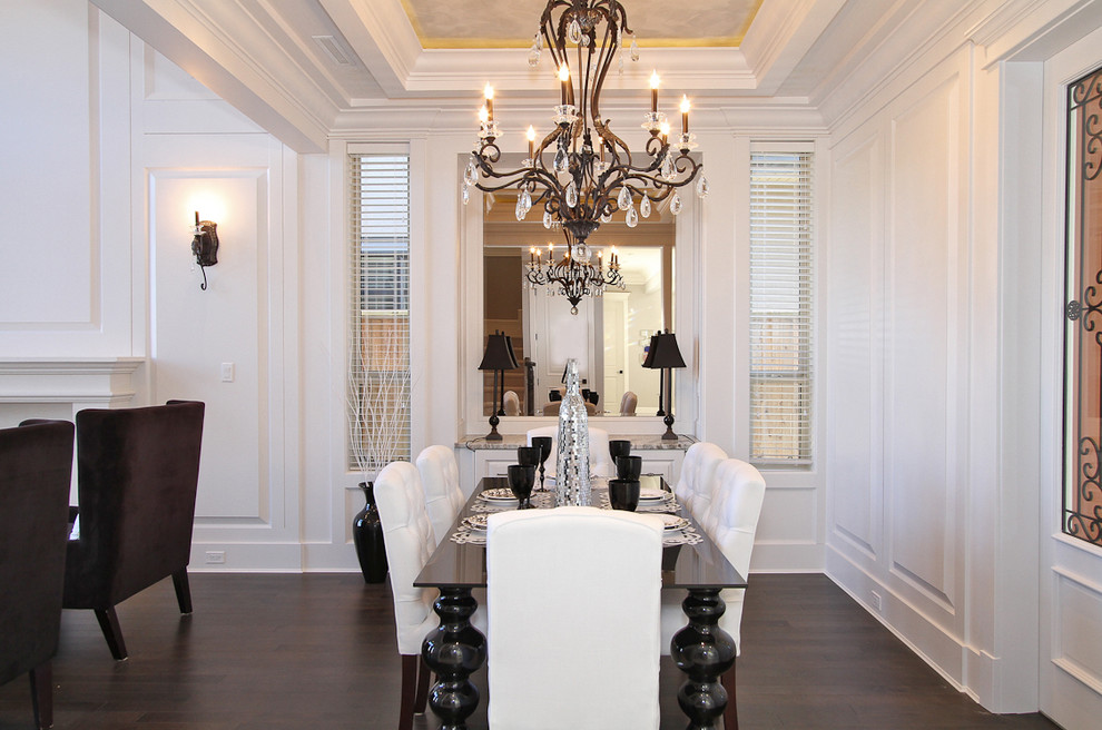 Immagine di una sala da pranzo aperta verso il soggiorno tradizionale di medie dimensioni con pareti bianche, parquet scuro e nessun camino