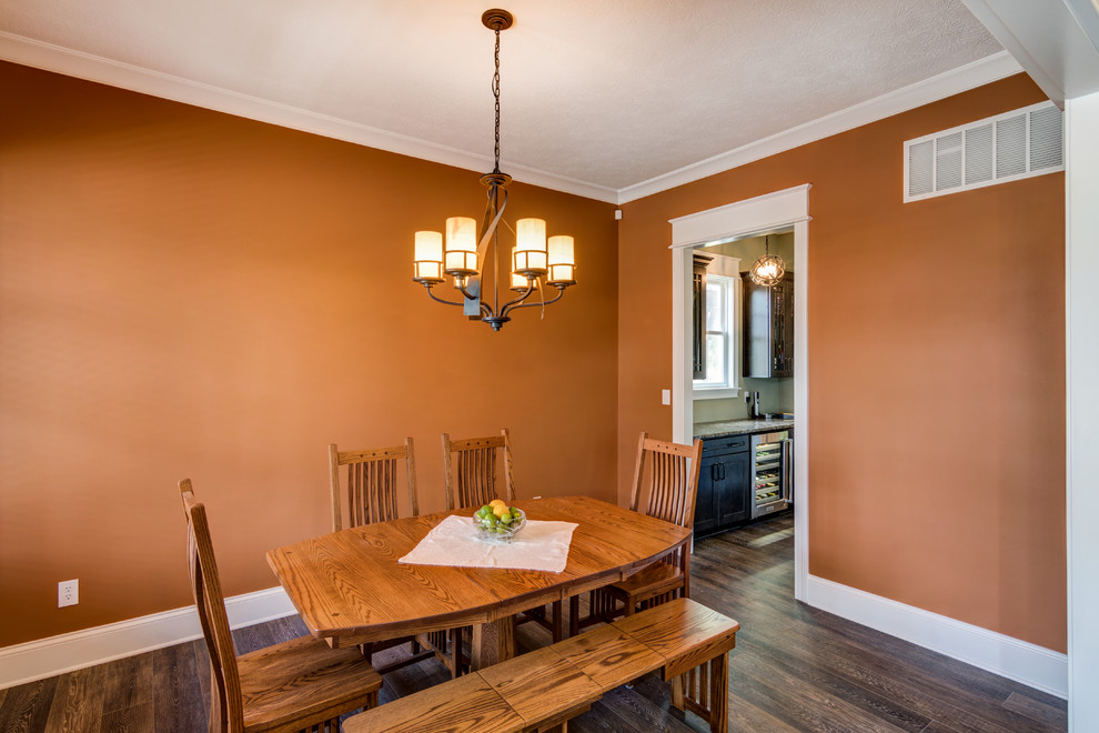 Foto di una sala da pranzo stile americano con pareti arancioni e parquet scuro