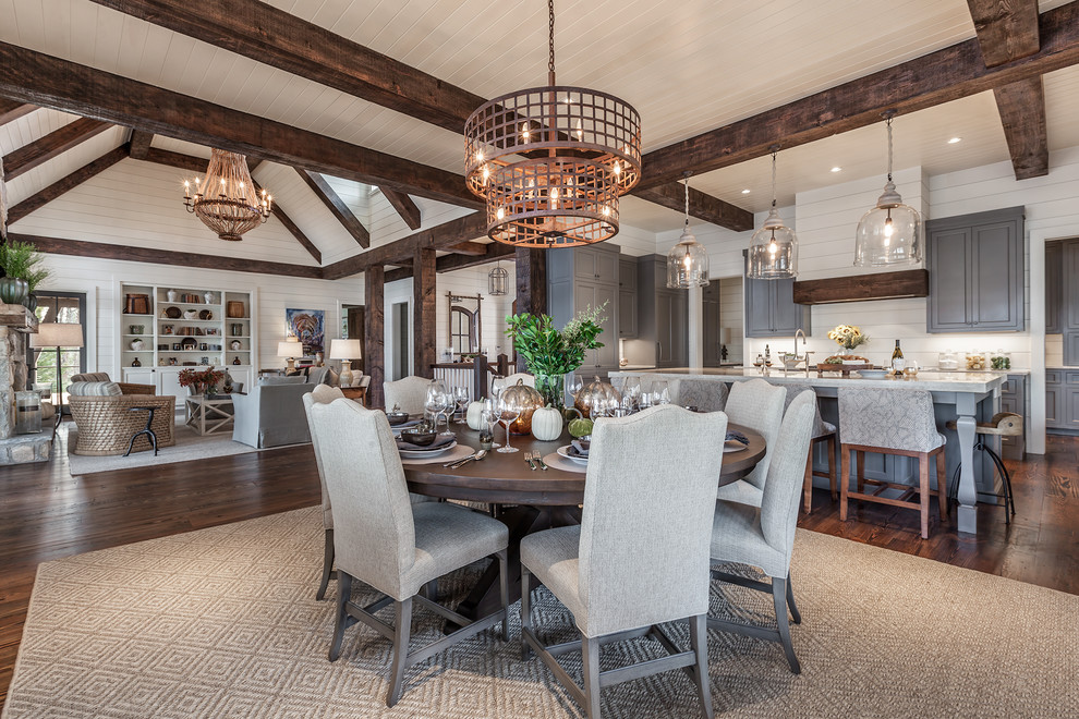 This is an example of a large farmhouse open plan dining room in Other with white walls, dark hardwood flooring, no fireplace and feature lighting.