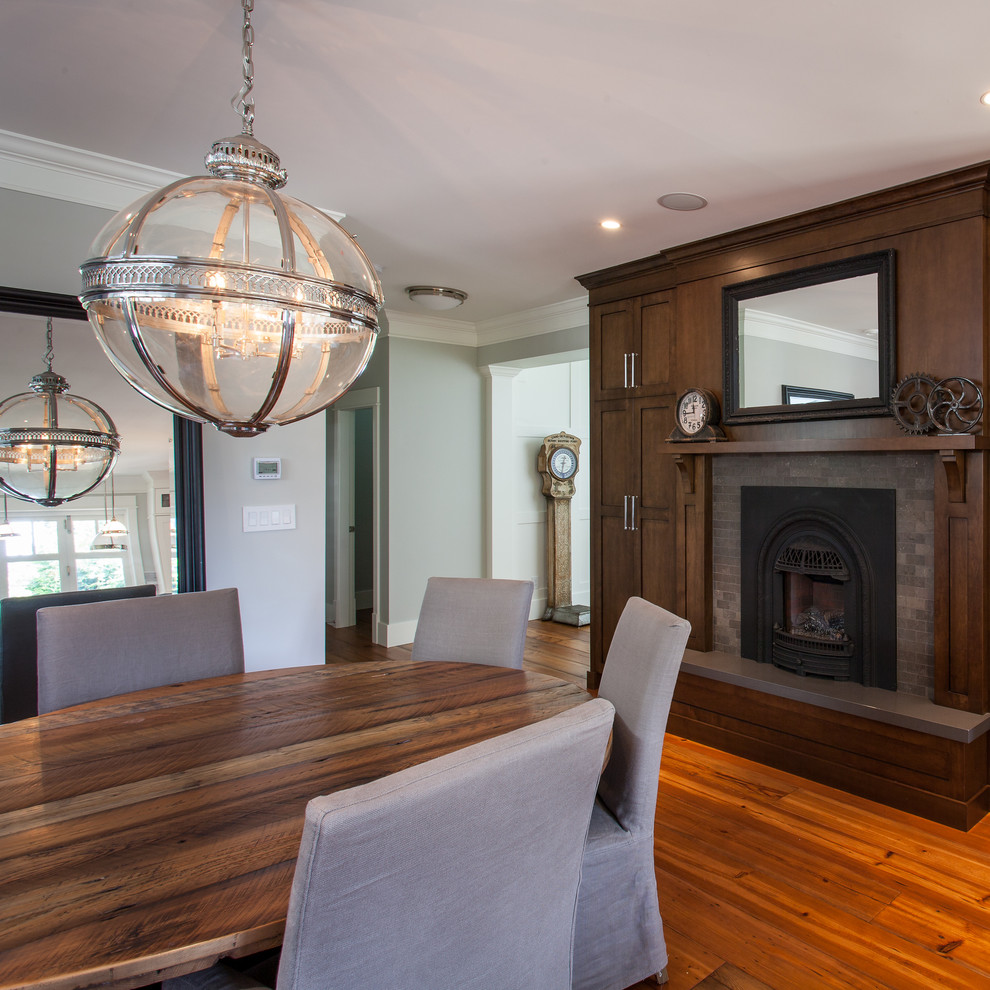 Photo of a large traditional enclosed dining room in Vancouver with grey walls, medium hardwood flooring, a standard fireplace and a tiled fireplace surround.