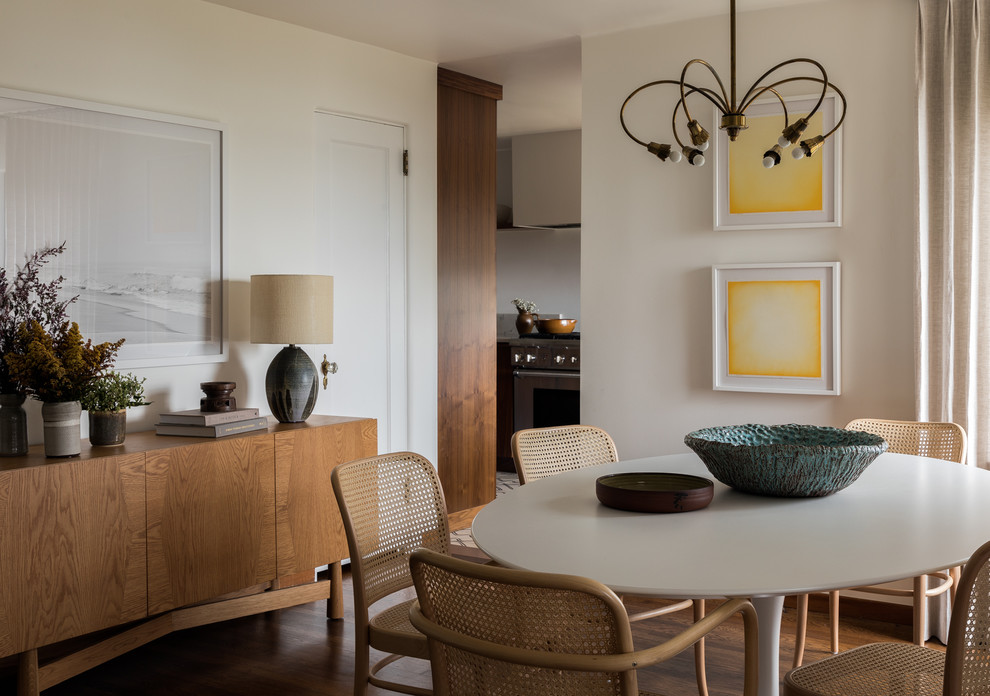 Idée de décoration pour une salle à manger vintage avec un mur blanc, un sol en bois brun, un sol marron et éclairage.