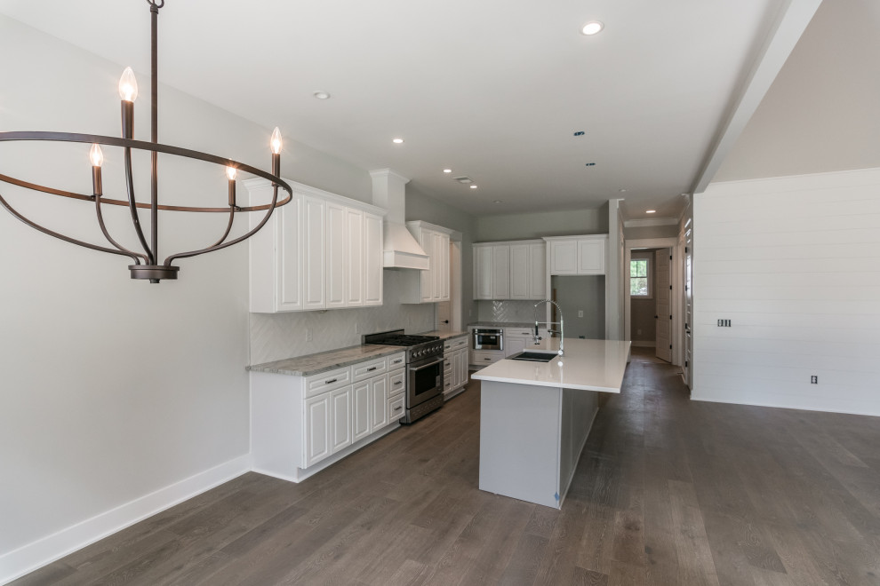 Example of a mid-sized cottage vinyl floor and brown floor kitchen/dining room combo design in Nashville with gray walls, a standard fireplace and a stone fireplace