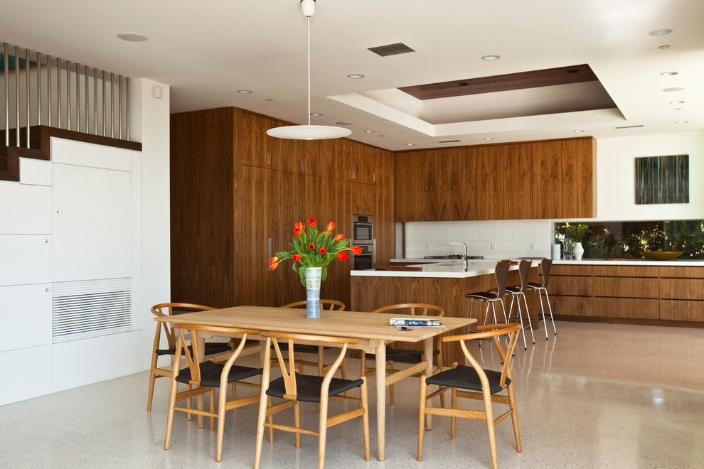 Immagine di una sala da pranzo moderna con pareti bianche, pavimento in cemento e pavimento grigio