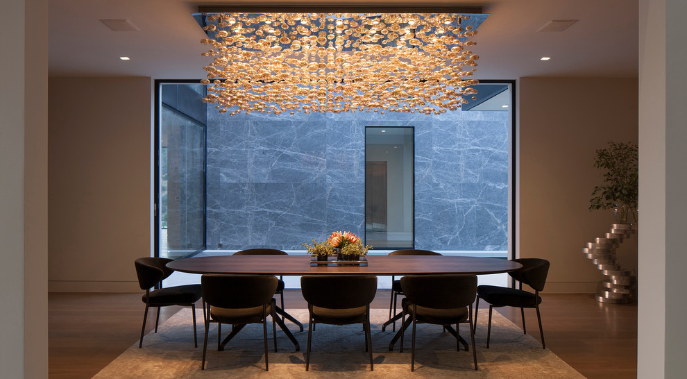 Idée de décoration pour une salle à manger design avec un mur gris et parquet foncé.