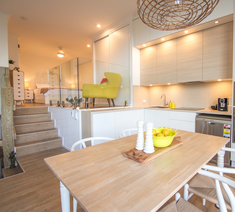 Ispirazione per una piccola sala da pranzo aperta verso la cucina stile marinaro con pareti bianche e pavimento in vinile