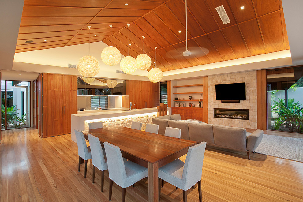 Idées déco pour une salle à manger ouverte sur le salon contemporaine avec un sol en bois brun.