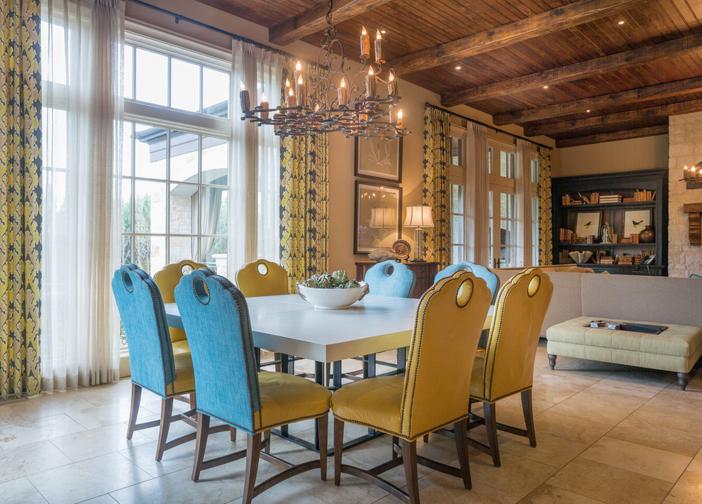 Example of a large tuscan limestone floor kitchen/dining room combo design in Atlanta with beige walls, a standard fireplace and a stone fireplace