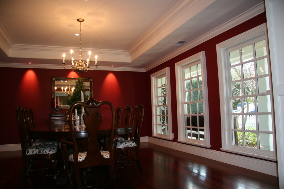 Esempio di una sala da pranzo tradizionale chiusa e di medie dimensioni con pareti rosse, parquet scuro e nessun camino