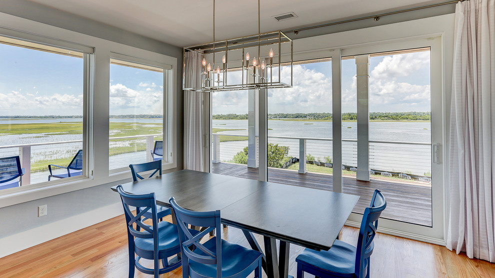 Ispirazione per una sala da pranzo stile marinaro con pareti blu, parquet chiaro e pavimento marrone