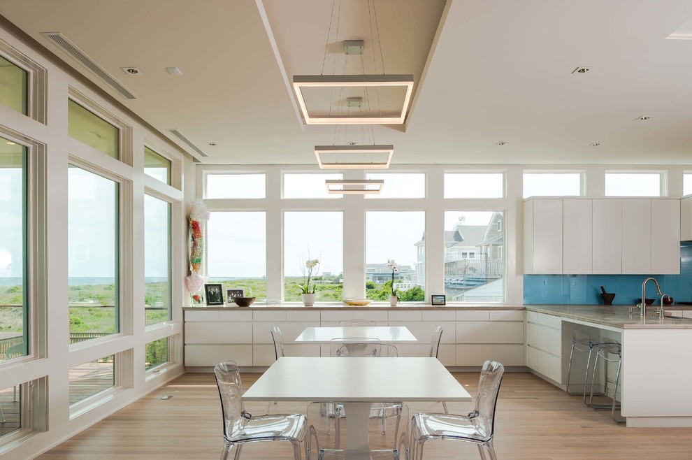 Immagine di una grande sala da pranzo aperta verso la cucina stile marinaro con pareti bianche