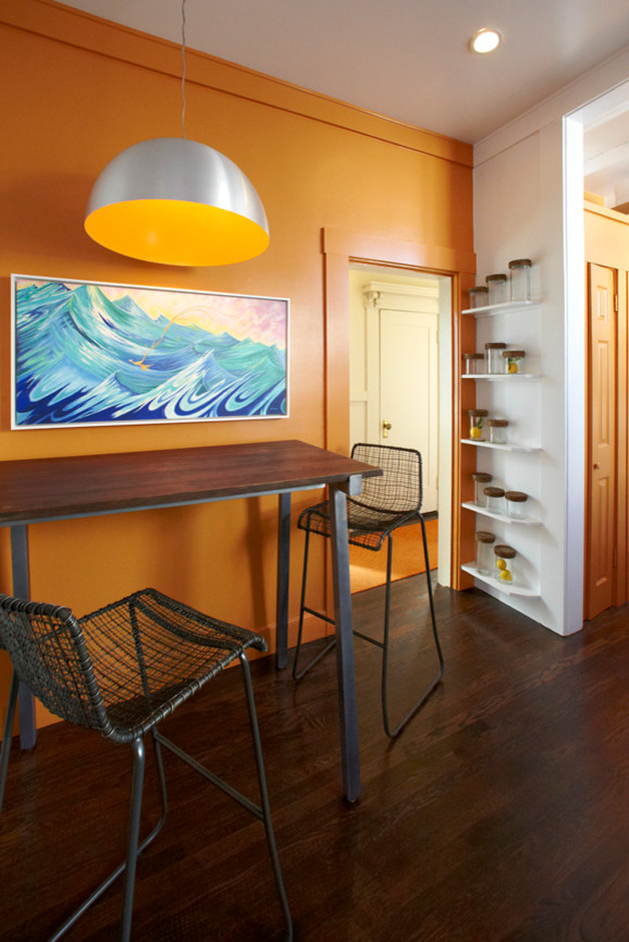 Réalisation d'une salle à manger marine fermée et de taille moyenne avec un mur orange et un sol en bois brun.