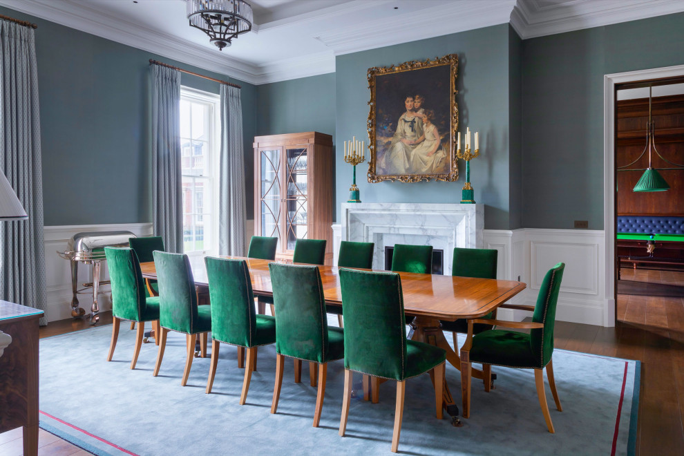 Esempio di una sala da pranzo classica chiusa con pareti blu, pavimento in legno massello medio, camino classico, cornice del camino in pietra e boiserie
