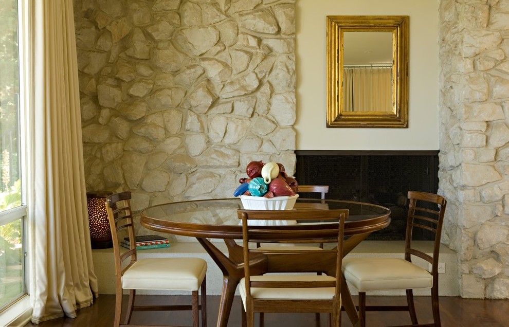 Aménagement d'une salle à manger classique avec un mur beige, parquet foncé, un manteau de cheminée en pierre et une cheminée ribbon.