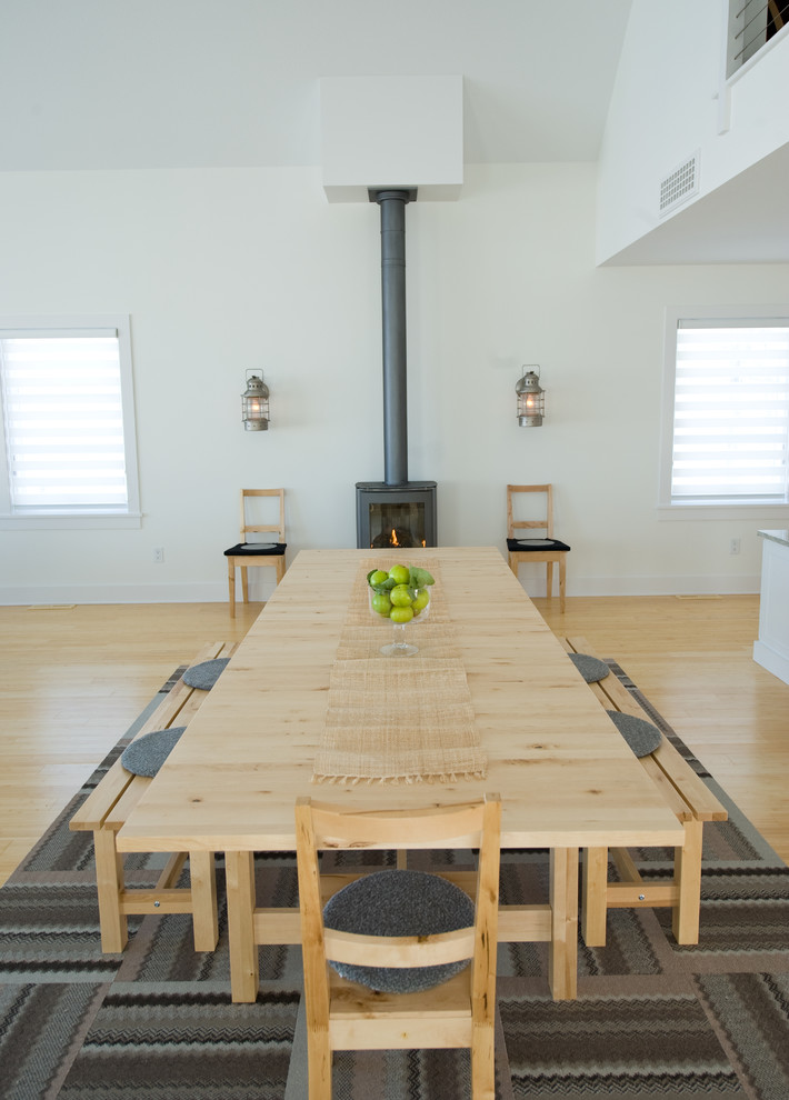 Inspiration for a scandinavian medium tone wood floor dining room remodel in Minneapolis with white walls and a wood stove