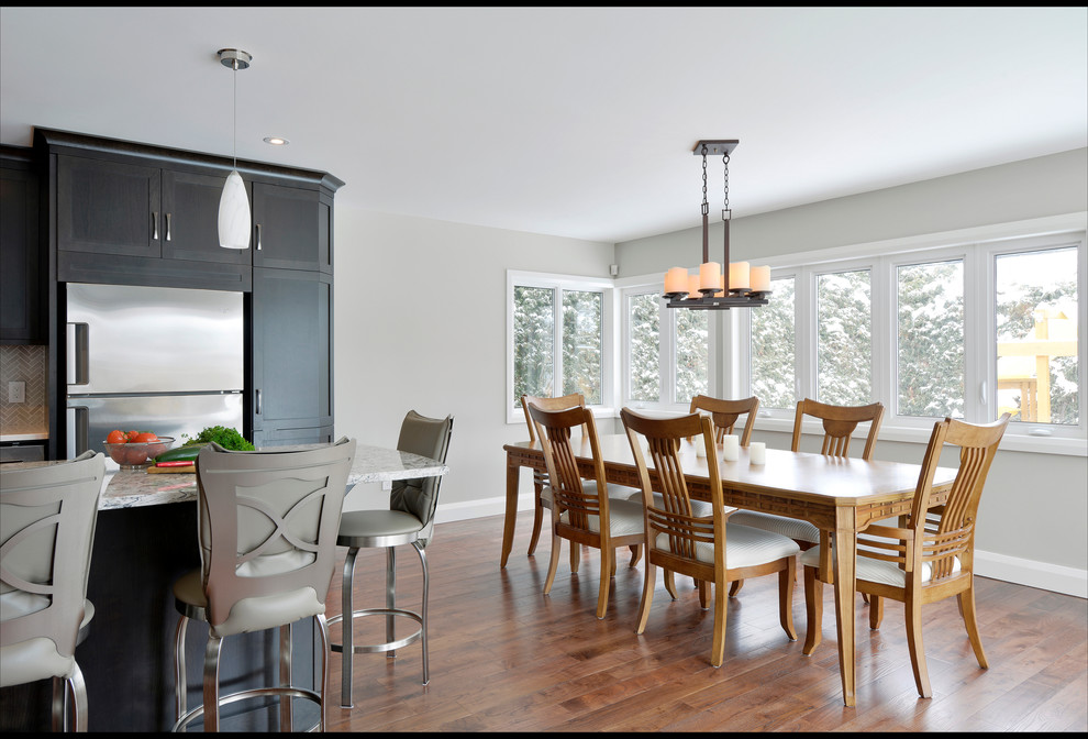 This is an example of a medium sized classic kitchen/dining room in Ottawa with grey walls, medium hardwood flooring, a standard fireplace and a stone fireplace surround.