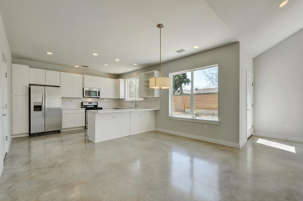 This is an example of a medium sized modern kitchen/dining room in Austin with concrete flooring.