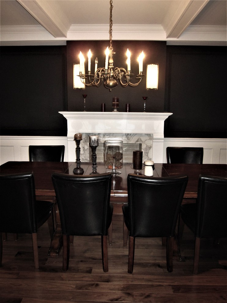 Geschlossenes Klassisches Esszimmer mit schwarzer Wandfarbe, braunem Holzboden, Kamin, Kaminumrandung aus Holz und braunem Boden in Sonstige
