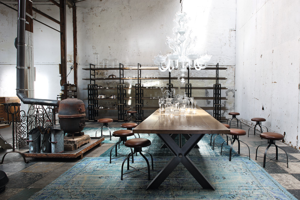 Immagine di una grande sala da pranzo industriale chiusa con pareti bianche, pavimento in gres porcellanato e stufa a legna