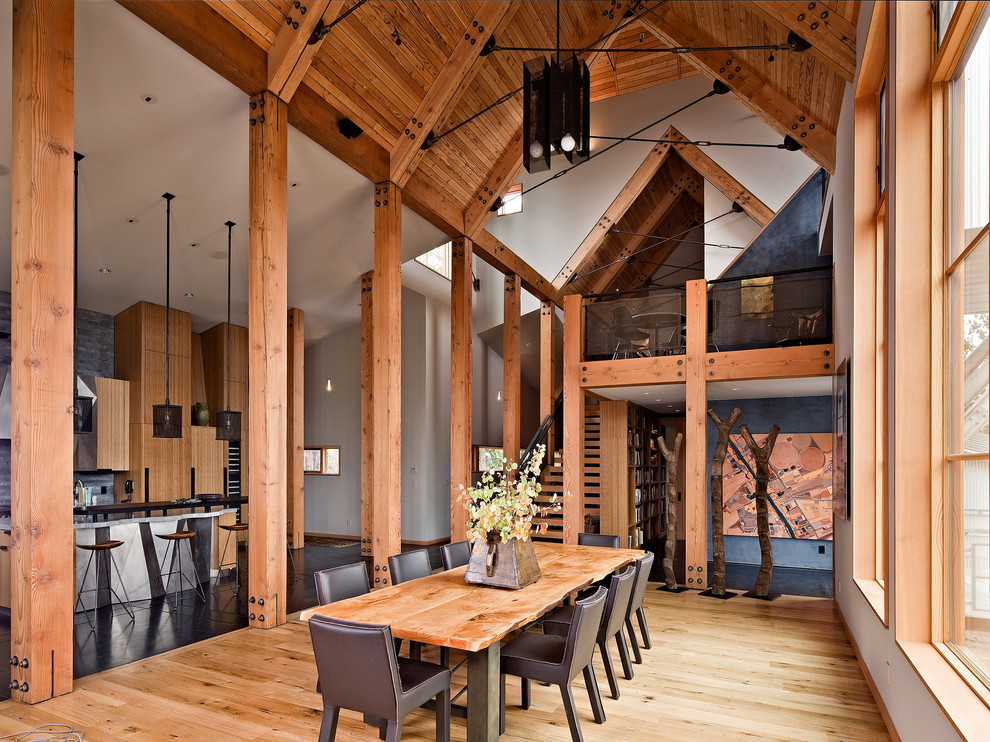 Idee per una sala da pranzo aperta verso la cucina rustica con pareti bianche e pavimento in legno massello medio