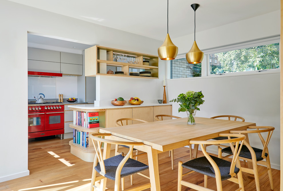 Foto di una sala da pranzo aperta verso la cucina minimalista di medie dimensioni con pareti bianche, parquet chiaro e pavimento beige