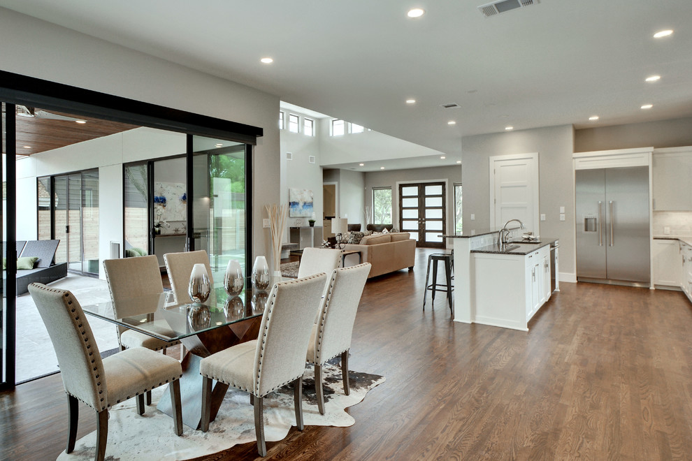 Medium sized modern open plan dining room in Austin with grey walls, medium hardwood flooring and feature lighting.