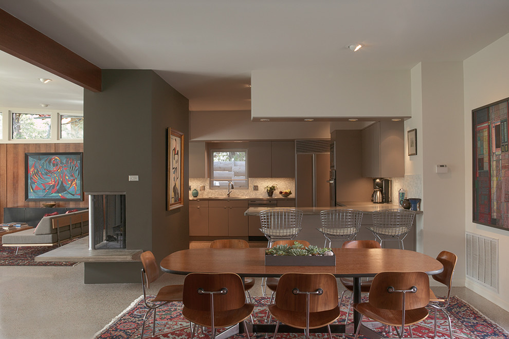 Immagine di una sala da pranzo aperta verso il soggiorno moderna con camino classico