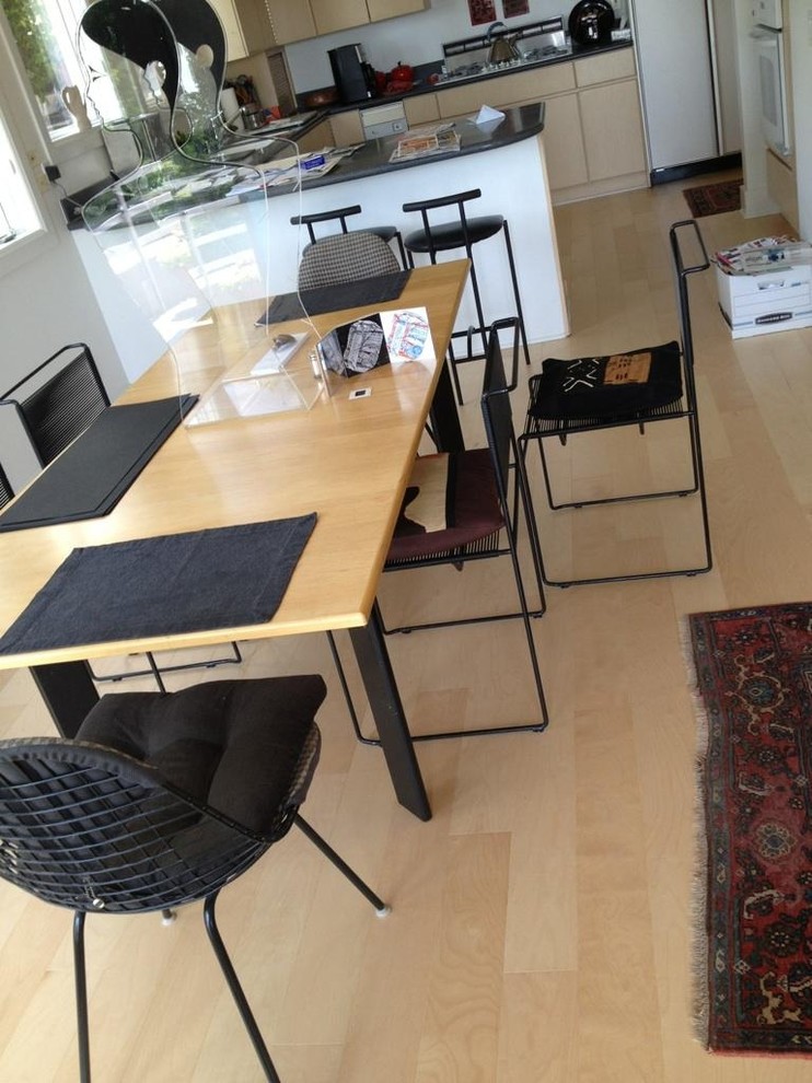 Esempio di una sala da pranzo aperta verso la cucina minimalista di medie dimensioni con pareti bianche, parquet chiaro e nessun camino