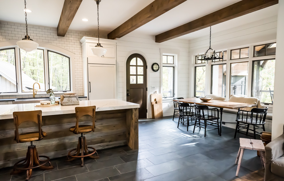 Immagine di una sala da pranzo aperta verso la cucina country con pareti bianche, pavimento in ardesia e pavimento blu