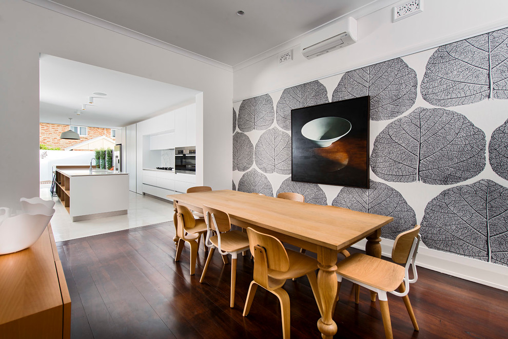 Aménagement d'une salle à manger ouverte sur la cuisine contemporaine avec un mur multicolore, un sol en bois brun et aucune cheminée.