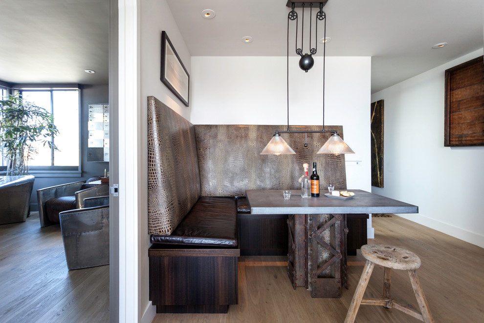 Inspiration pour une salle à manger urbaine avec un mur blanc, un sol en bois brun et éclairage.