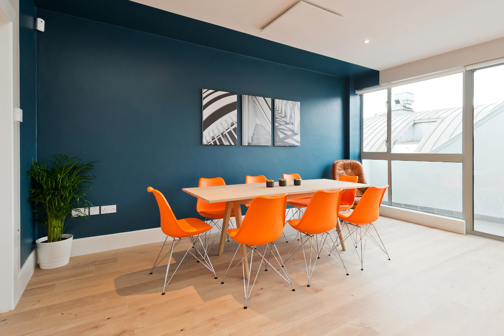 Esempio di una sala da pranzo aperta verso il soggiorno contemporanea di medie dimensioni con pareti blu, pavimento in laminato e nessun camino