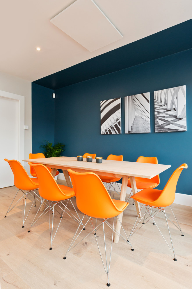 Immagine di una sala da pranzo aperta verso il soggiorno minimal di medie dimensioni con pareti multicolore, pavimento in laminato e nessun camino