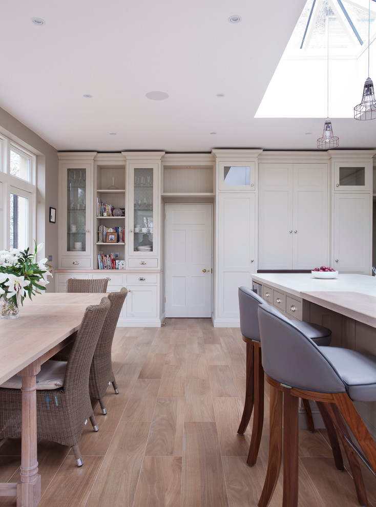 Aménagement d'une salle à manger ouverte sur la cuisine classique avec un sol en bois brun.