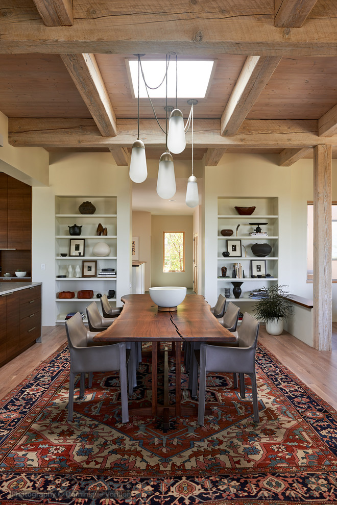 Foto di una sala da pranzo aperta verso la cucina contemporanea con pareti bianche, pavimento in legno massello medio, nessun camino e pavimento marrone