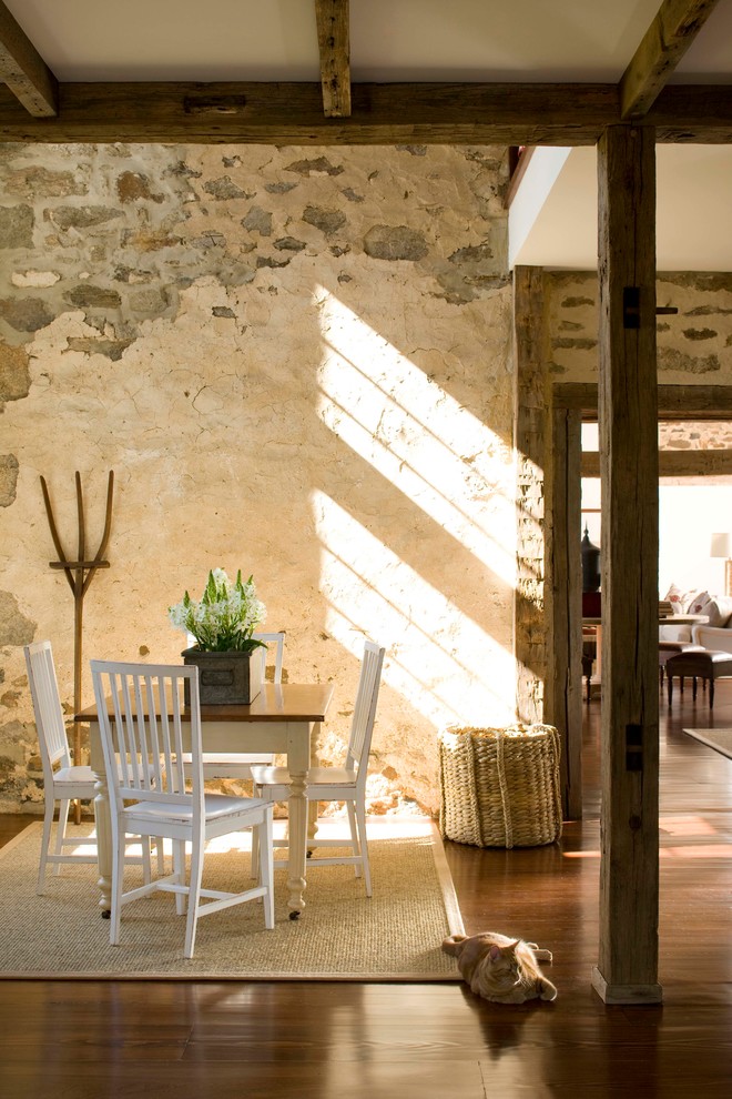 Cette photo montre une salle à manger ouverte sur la cuisine nature avec parquet foncé et un mur beige.