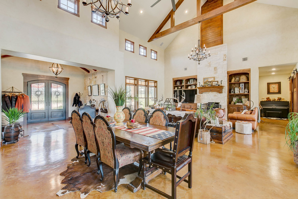 Photo of an open plan dining room in Dallas with white walls, concrete flooring and brown floors.