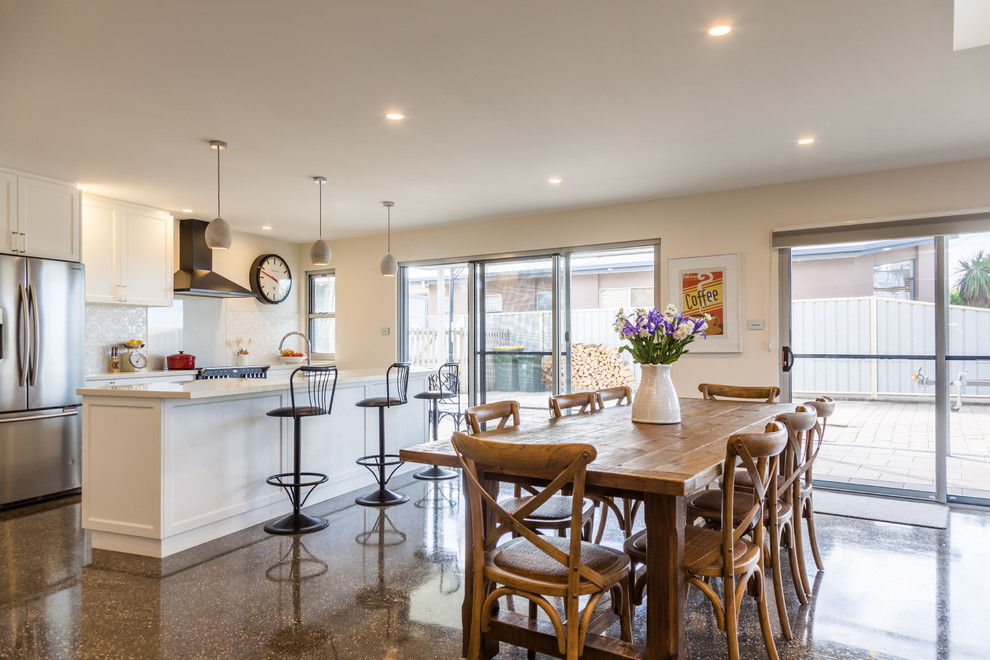 Стильный дизайн: кухня-столовая среднего размера в стиле кантри с белыми стенами и бетонным полом без камина - последний тренд
