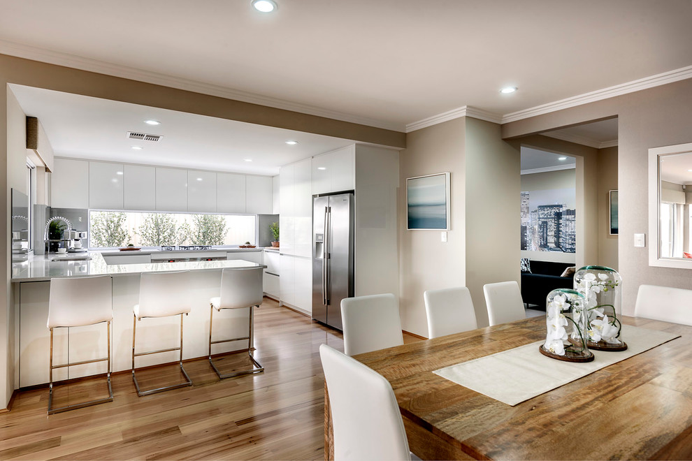 Cette photo montre une salle à manger ouverte sur le salon moderne de taille moyenne avec un mur beige et parquet clair.