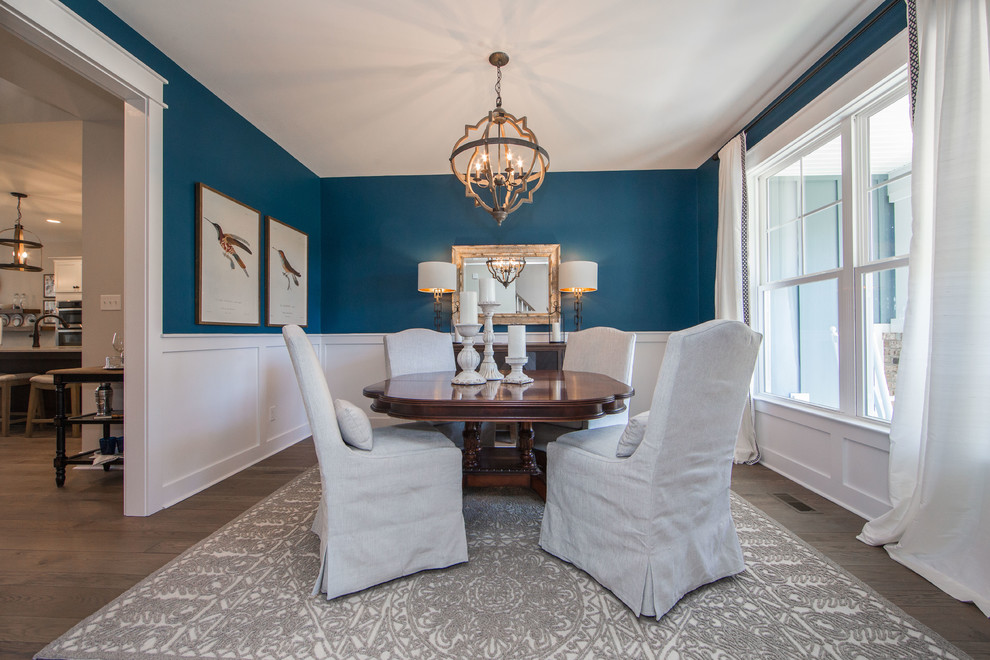 Immagine di una sala da pranzo aperta verso la cucina american style di medie dimensioni con pareti blu, pavimento in legno massello medio e pavimento marrone