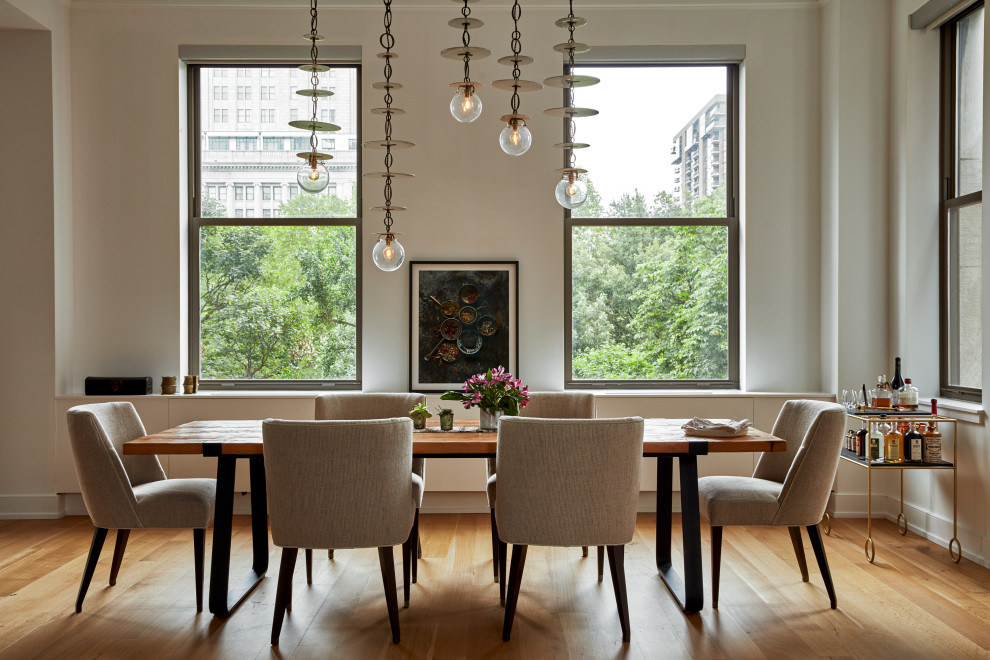 На фото: столовая в стиле неоклассика (современная классика) с белыми стенами, паркетным полом среднего тона и коричневым полом с