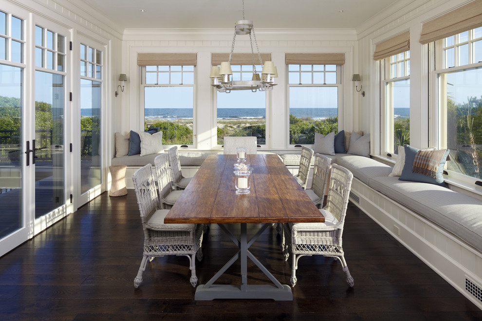 Example of a beach style dark wood floor and brown floor dining room design in Charleston with white walls