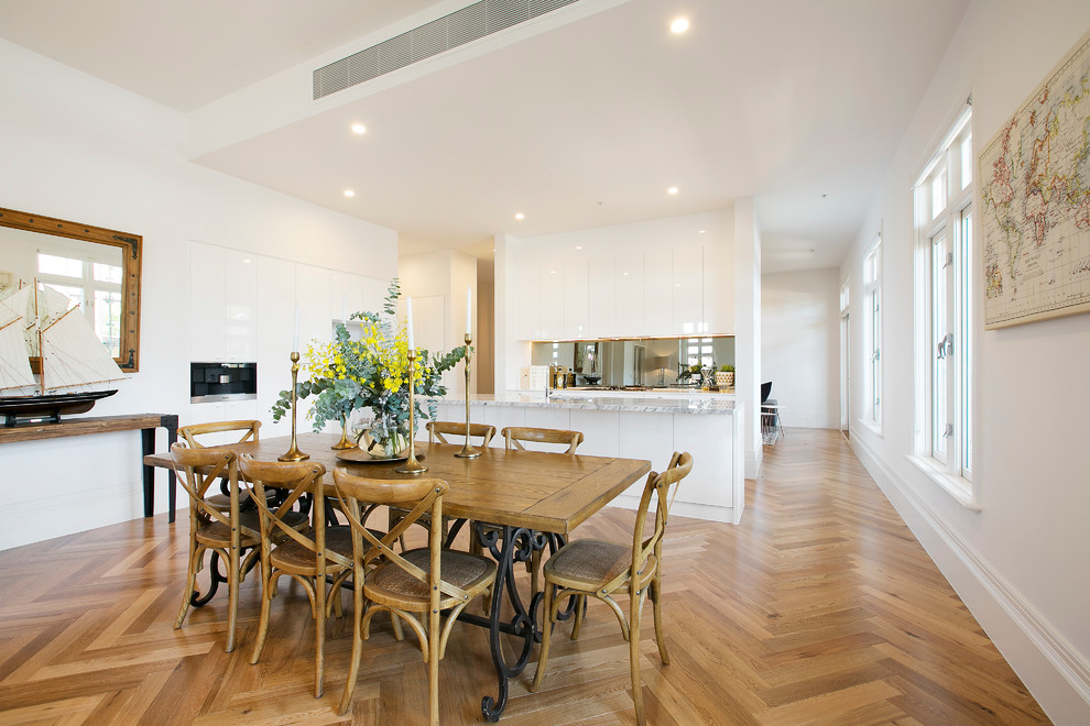 Idee per una sala da pranzo aperta verso il soggiorno contemporanea con pareti bianche e pavimento in legno massello medio