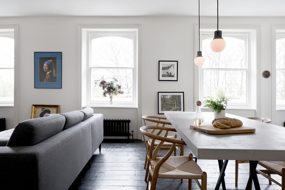 Aménagement d'une salle à manger ouverte sur le salon contemporaine de taille moyenne avec un mur blanc, parquet foncé et un sol noir.