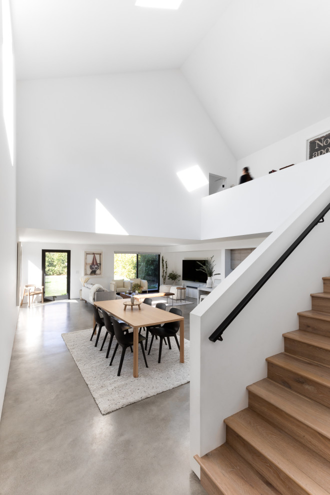 Kleine Moderne Wohnküche ohne Kamin mit weißer Wandfarbe, Betonboden, grauem Boden und gewölbter Decke in Los Angeles