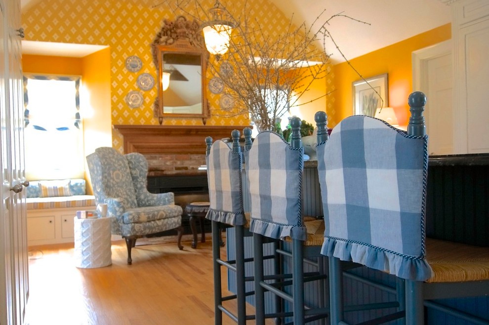Réalisation d'une salle à manger tradition avec un mur jaune, parquet clair, une cheminée standard et un manteau de cheminée en brique.