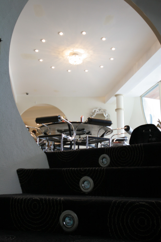 Foto di un'ampia sala da pranzo aperta verso il soggiorno design con pareti bianche, moquette e pavimento nero