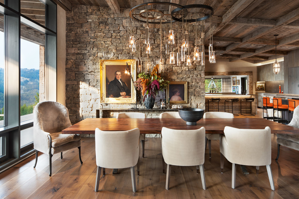 Immagine di una sala da pranzo aperta verso il soggiorno stile rurale con pareti beige, parquet scuro e pavimento marrone