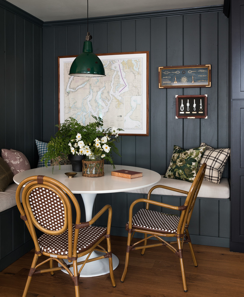 Immagine di una sala da pranzo aperta verso la cucina rustica con pareti verdi, pavimento in legno massello medio e pavimento marrone