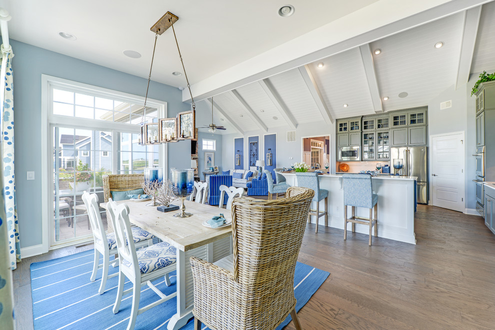 Foto di una sala da pranzo aperta verso il soggiorno costiera con pareti blu e parquet chiaro